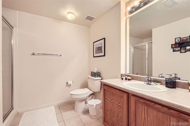 bathroom featuring tile patterned flooring, vanity, toilet, and a shower with shower door