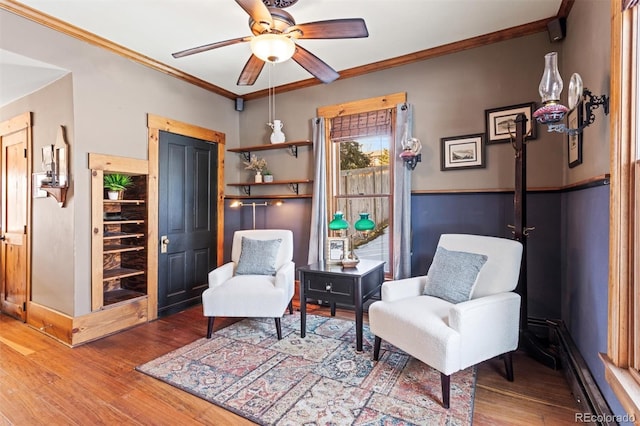 living area with hardwood / wood-style floors, ornamental molding, and ceiling fan