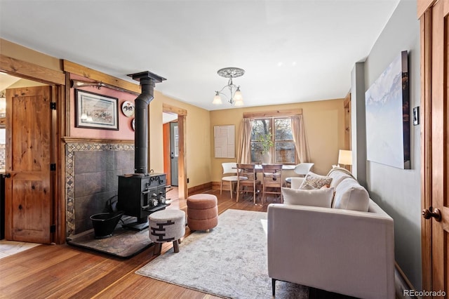 living room featuring a notable chandelier, hardwood / wood-style floors, and a wood stove