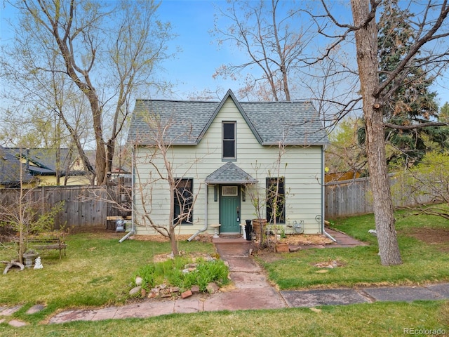 bungalow-style house with a front yard, a shingled roof, and fence