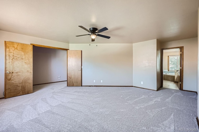 unfurnished bedroom featuring ceiling fan, light carpet, and connected bathroom