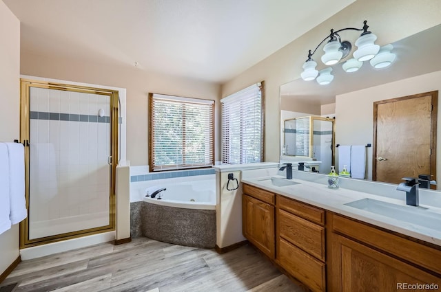 bathroom featuring hardwood / wood-style floors, vanity, and shower with separate bathtub