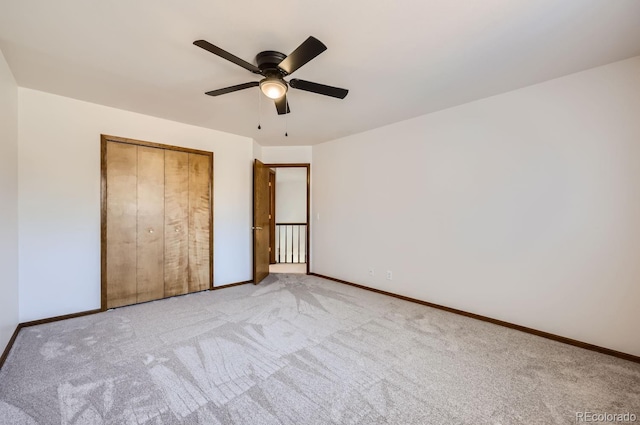 unfurnished bedroom with a closet, light colored carpet, and ceiling fan