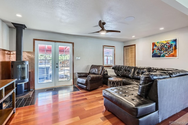 living room with wood-type flooring, a textured ceiling, french doors, and ceiling fan