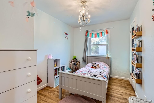 bedroom featuring light hardwood / wood-style flooring and a chandelier