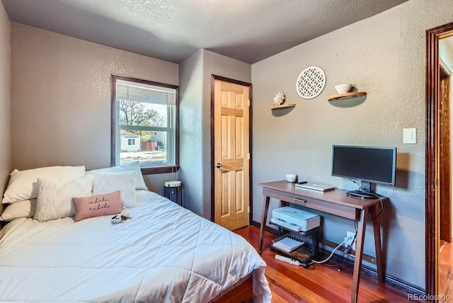 bedroom featuring hardwood / wood-style flooring and a textured ceiling