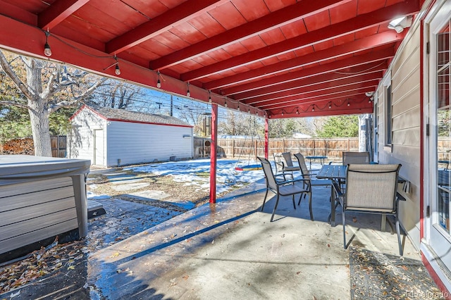 view of patio with a storage shed and a hot tub