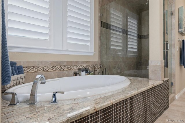 bathroom featuring a shower stall and a bathtub