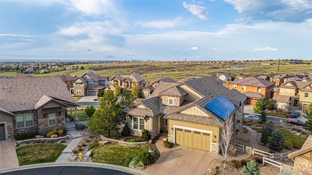 view of front of home featuring a residential view, an attached garage, driveway, and stone siding