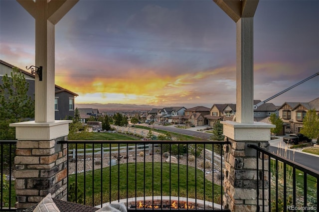 balcony at dusk featuring a residential view