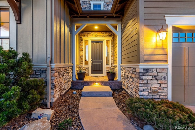 doorway to property featuring board and batten siding, a porch, and stone siding