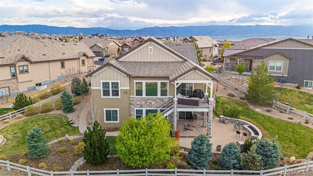 exterior space with board and batten siding, a deck with mountain view, stairway, and a fenced backyard