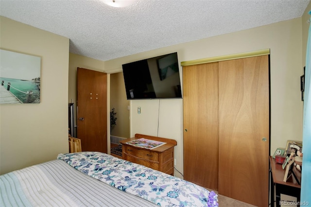 bedroom with a textured ceiling and a closet