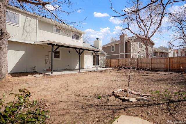 rear view of property featuring a patio and fence