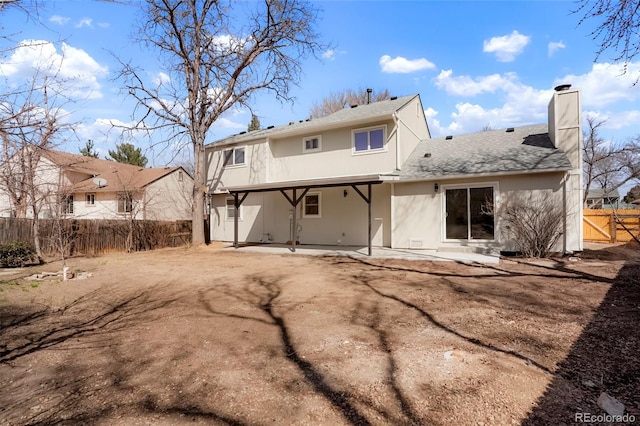 rear view of property featuring a patio, fence, a shingled roof, stucco siding, and a chimney