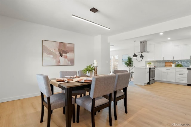 dining room with recessed lighting, baseboards, and light wood-type flooring