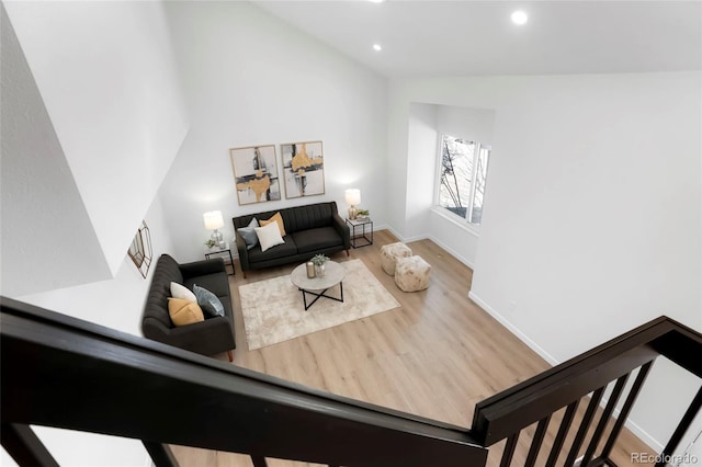 living area with recessed lighting, baseboards, wood finished floors, and vaulted ceiling