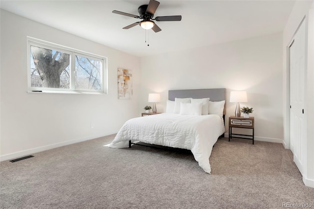 carpeted bedroom with visible vents, baseboards, a closet, and ceiling fan