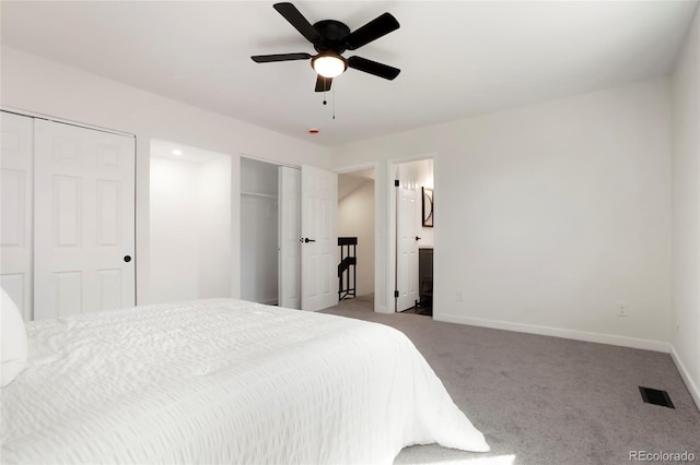 bedroom featuring visible vents, baseboards, multiple closets, carpet floors, and ensuite bathroom