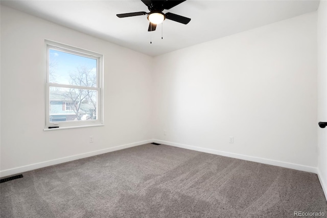 carpeted empty room with visible vents, baseboards, and ceiling fan