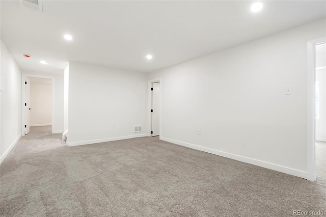 carpeted empty room featuring recessed lighting, visible vents, and baseboards