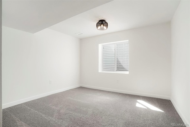 unfurnished room with carpet flooring and baseboards