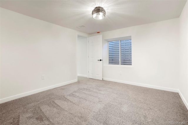 carpeted empty room with visible vents and baseboards