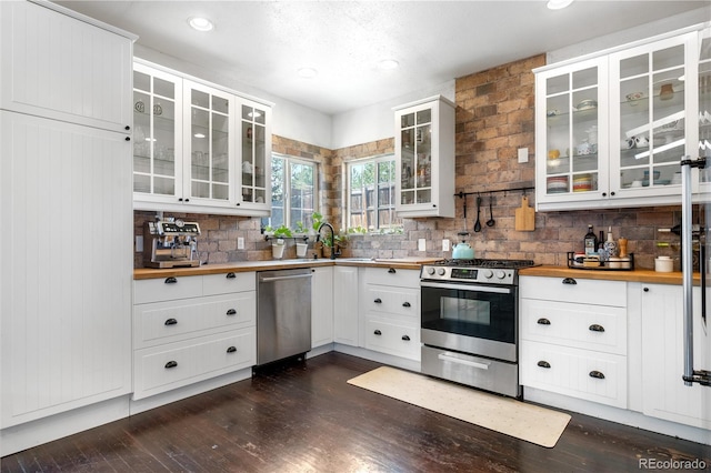 13349 Albion Cir, Thornton, CO 80241 - kitchen featuring appliances with stainless steel finishes, butcher block counters, backsplash, dark wood finished floors, and recessed lighting
