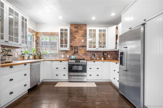 13349 Albion Cir, Thornton, CO 80241 - kitchen featuring appliances with stainless steel finishes, decorative backsplash, white cabinetry, glass insert cabinets, and recessed lighting