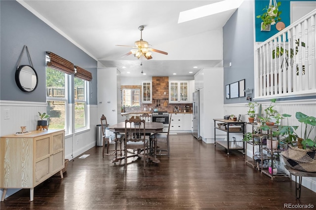 13349 Albion Cir, Thornton, CO 80241 - dining room featuring ceiling fan, a skylight, dark wood-style flooring, a wainscoted wall, and lofted ceiling