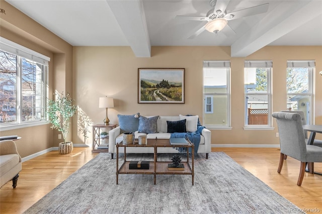 living room with beam ceiling, ceiling fan, and light hardwood / wood-style floors