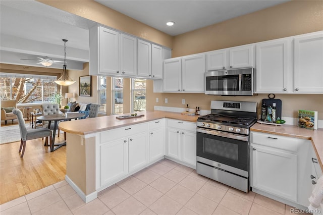 kitchen with white cabinets, appliances with stainless steel finishes, and plenty of natural light