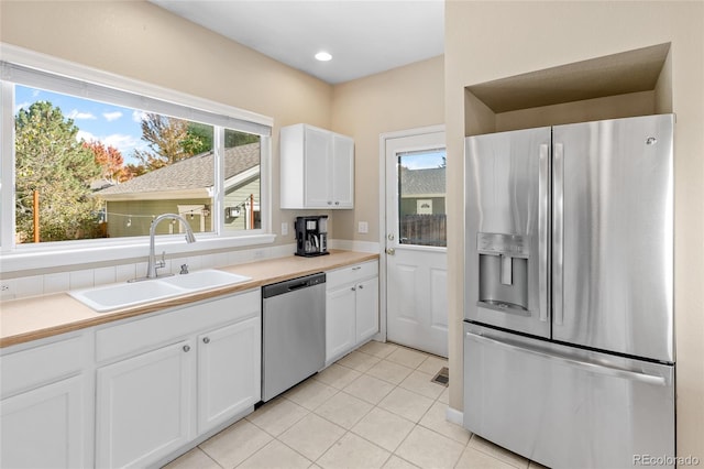 kitchen featuring white cabinetry, a wealth of natural light, sink, and appliances with stainless steel finishes