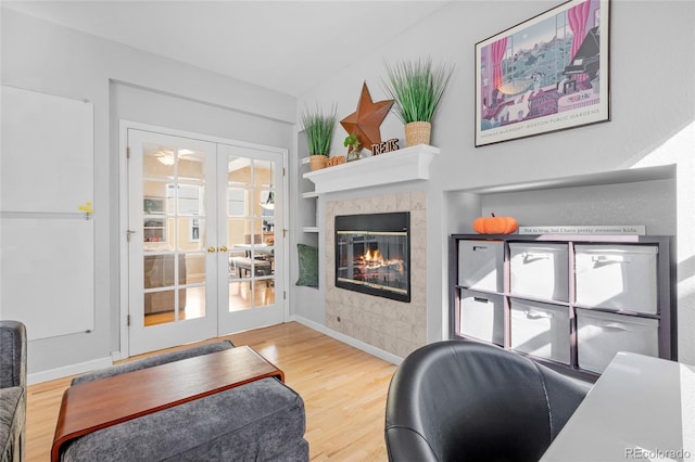 office area with a tiled fireplace, french doors, and hardwood / wood-style flooring