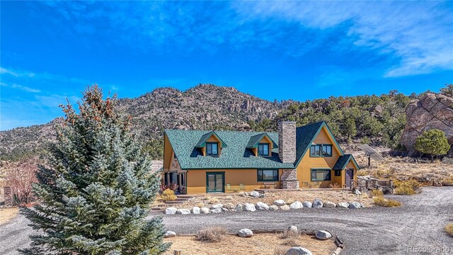 view of front of property with a chimney and a mountain view