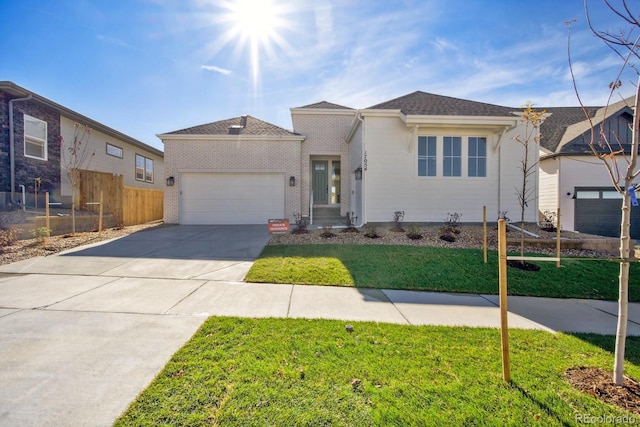 view of front of home featuring a garage, brick siding, fence, driveway, and a front lawn