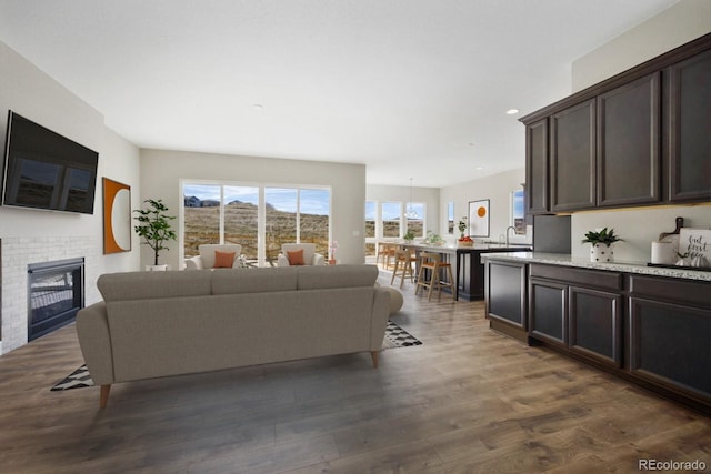 living area featuring dark wood-style floors, a fireplace, and recessed lighting