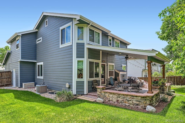 back of house with a ceiling fan, fence, a lawn, and a patio