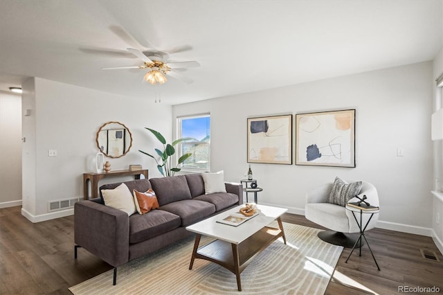 living room featuring a ceiling fan, wood finished floors, visible vents, and baseboards