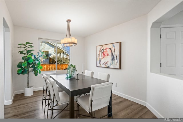 dining space featuring baseboards and dark wood-type flooring