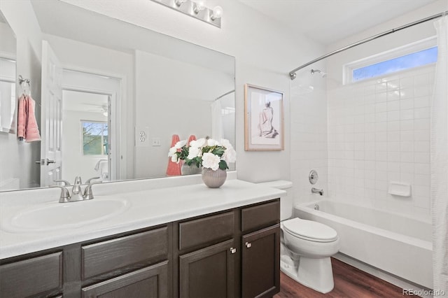 full bath featuring toilet, shower / bath combo with shower curtain, wood finished floors, and a wealth of natural light