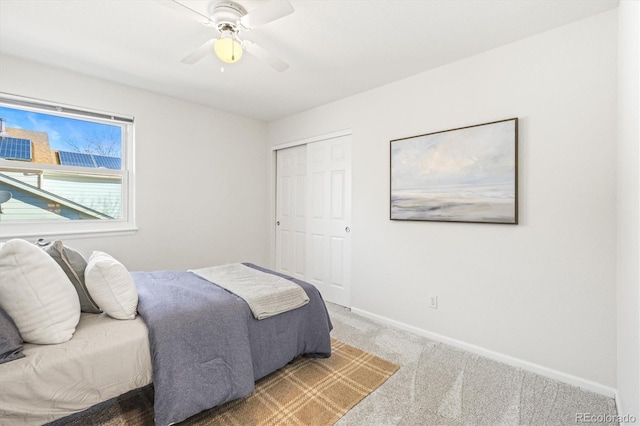 carpeted bedroom featuring ceiling fan, baseboards, and a closet