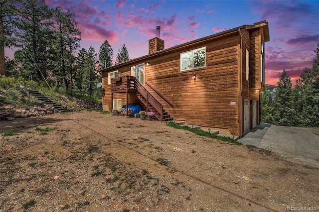 back house at dusk featuring a garage