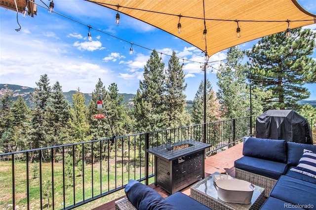 wooden terrace with an outdoor living space with a fire pit and a mountain view