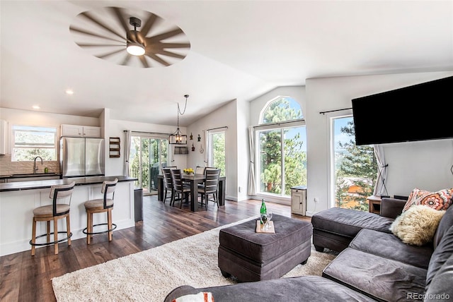 living room featuring ceiling fan, vaulted ceiling, and dark wood-type flooring