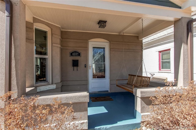 entrance to property featuring stucco siding and a porch