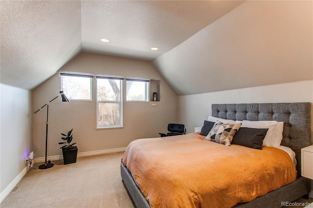 carpeted bedroom featuring a textured ceiling, lofted ceiling, and baseboards