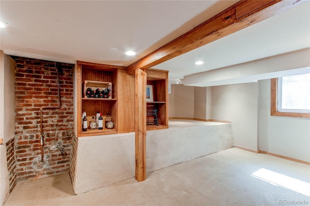 basement with brick wall, recessed lighting, baseboards, and carpet floors