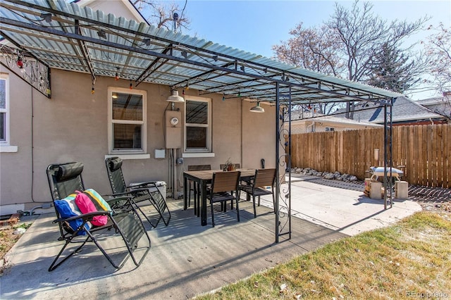 view of patio featuring outdoor dining space, a pergola, and fence