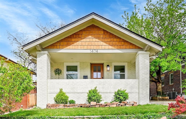 view of front facade featuring cooling unit, fence, and a porch